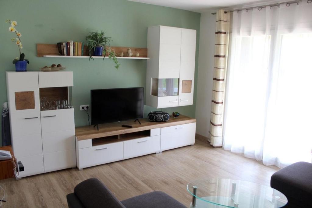 a living room with a television and white cabinets at Ferienhaus Nr 57, Kategorie Königscard, Feriendorf Hochbergle, Allgäu in Bichel