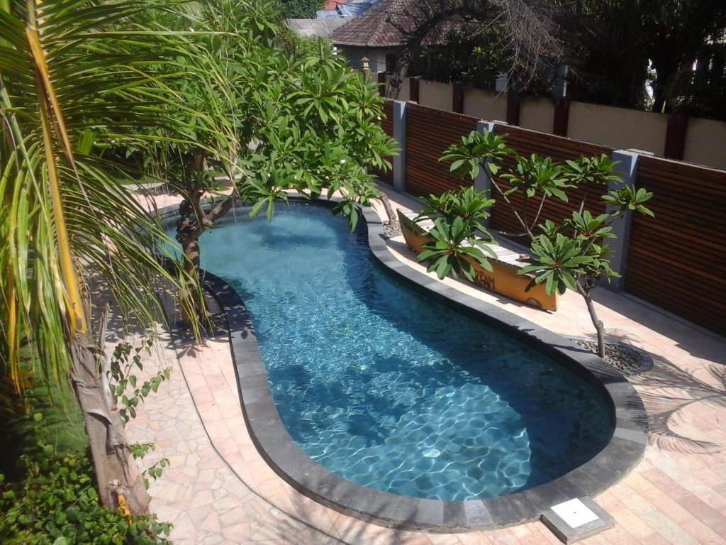 una piscina con una palmera en el patio trasero en Coconut Dream, en Gili Trawangan