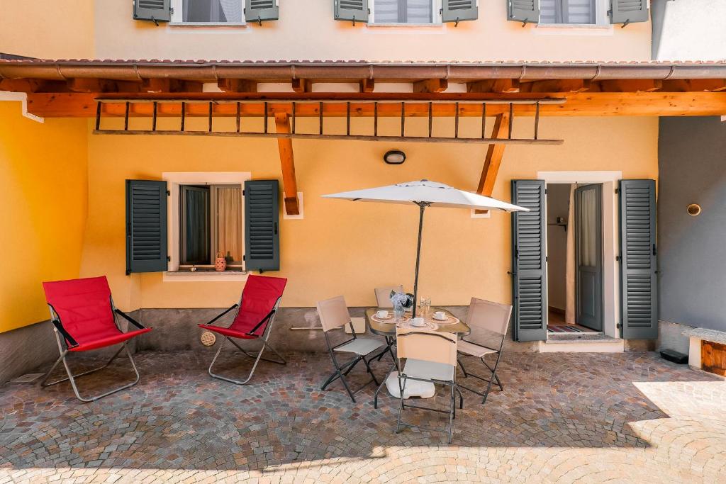 a patio with a table and chairs and an umbrella at Appartamento Gloria in Cannobio