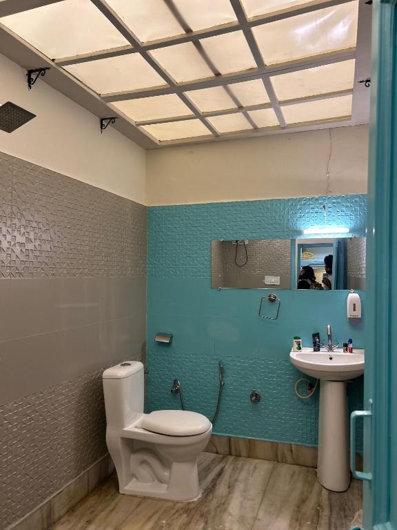 ein Badezimmer mit Toilette und Waschbecken in der Unterkunft Serendipity Hostel & Cats Cafe in Rishikesh