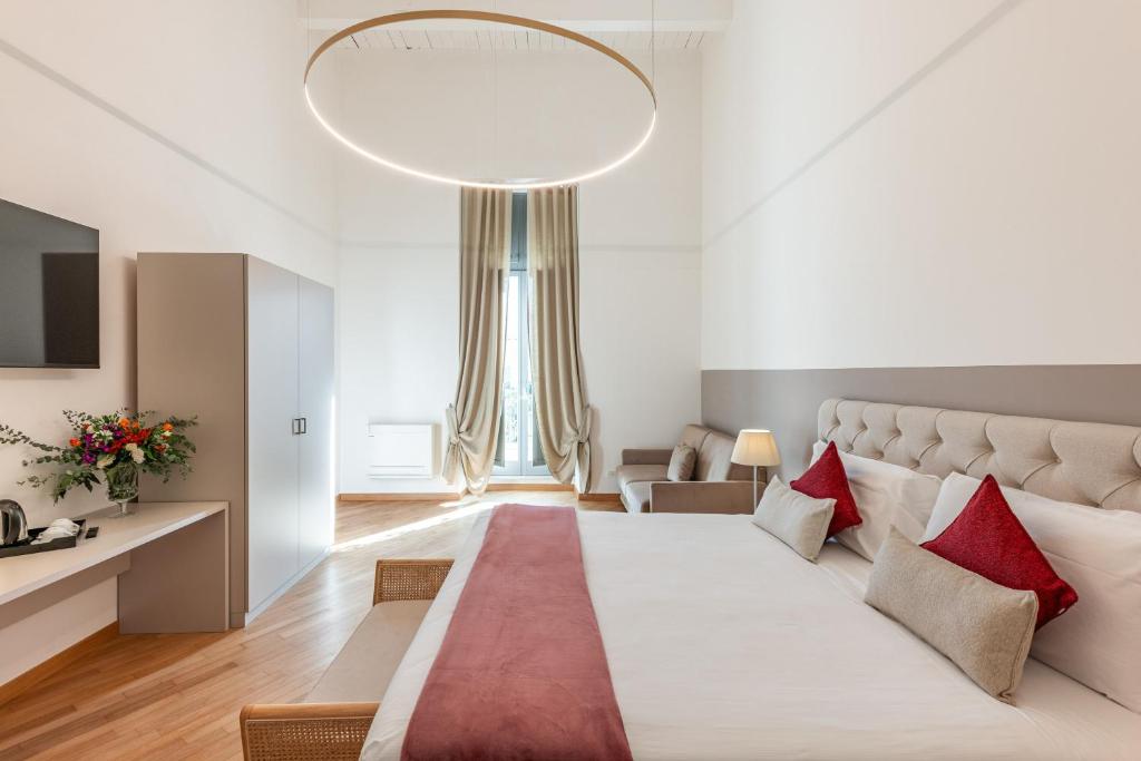 a bedroom with a large white bed with red pillows at Palazzo Indelli in Monopoli