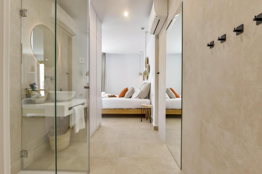 a bathroom with a mirror and a sink and a bed at MIMAR ALTEA ROOMS - Tranquil in Altea
