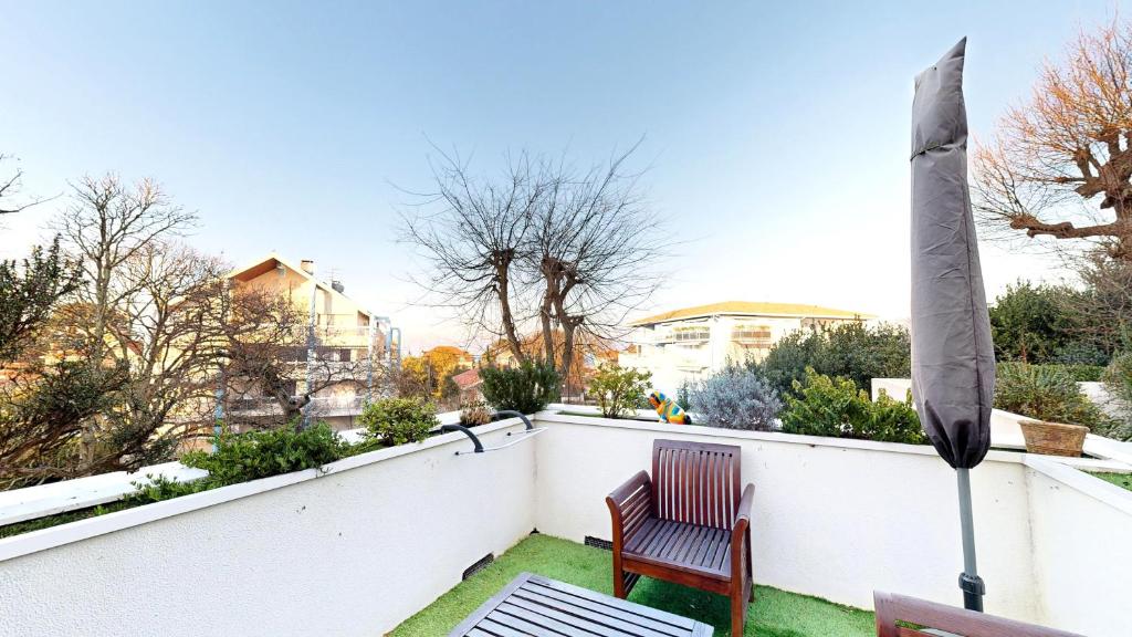 d'une terrasse avec une chaise sur une clôture blanche. dans l'établissement ARCACHON PLAGE Centrale, à Arcachon