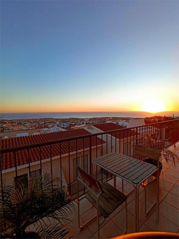 a view of the sunset from the balcony of a building at Green Oasis Penthouse in Peyia