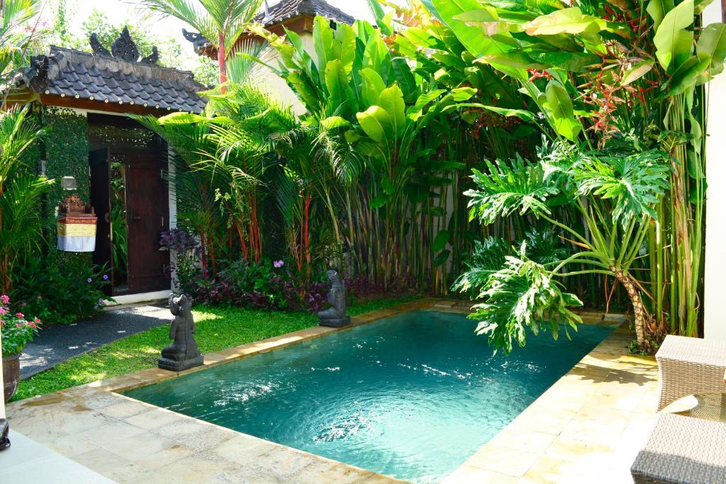 a swimming pool in the middle of a garden at Villa Cantik in Ubud