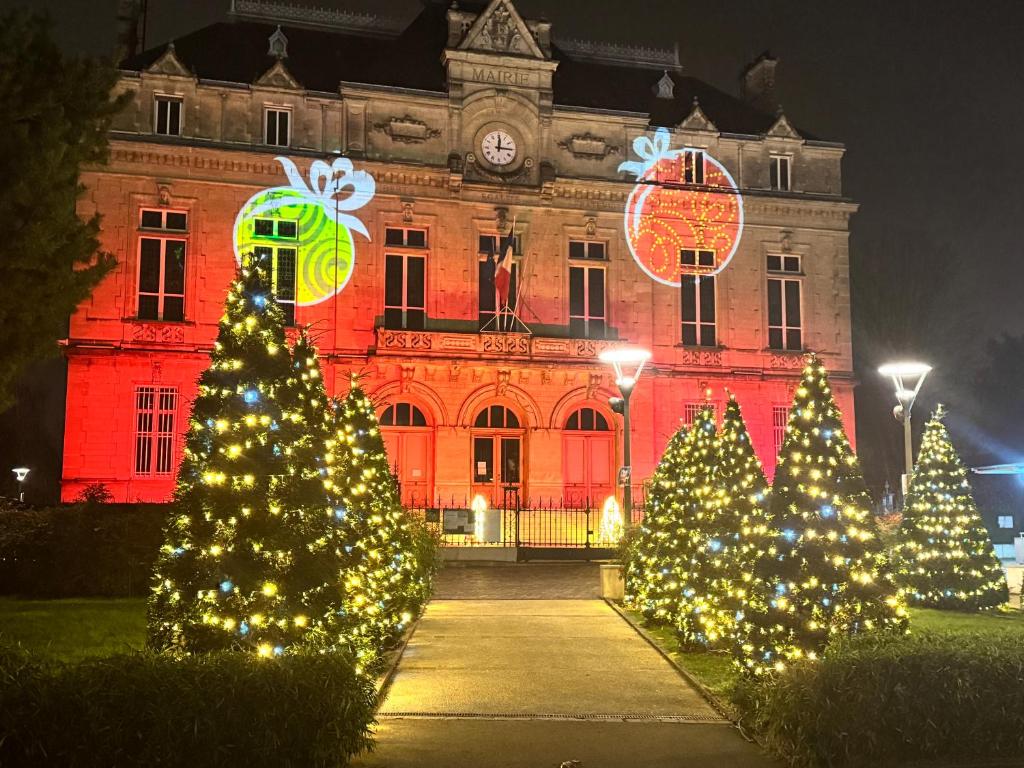 eine Gruppe von Weihnachtsbäumen vor einem Gebäude in der Unterkunft Close to Paris & Disney in Le Perreux-sur-Marne