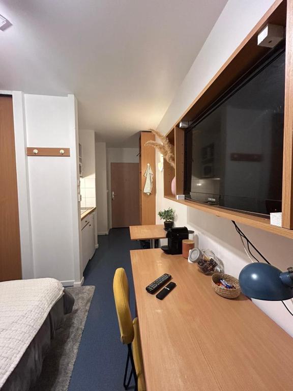 Cette chambre dispose d'un bureau et d'une grande télévision à écran plat. dans l'établissement Studio in Issy Les Moulineaux, à Issy-les-Moulineaux