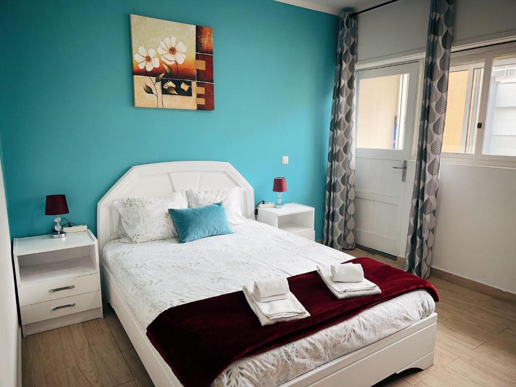 a bedroom with a white bed with blue walls at Ap Centro de Gaia in Vila Nova de Gaia