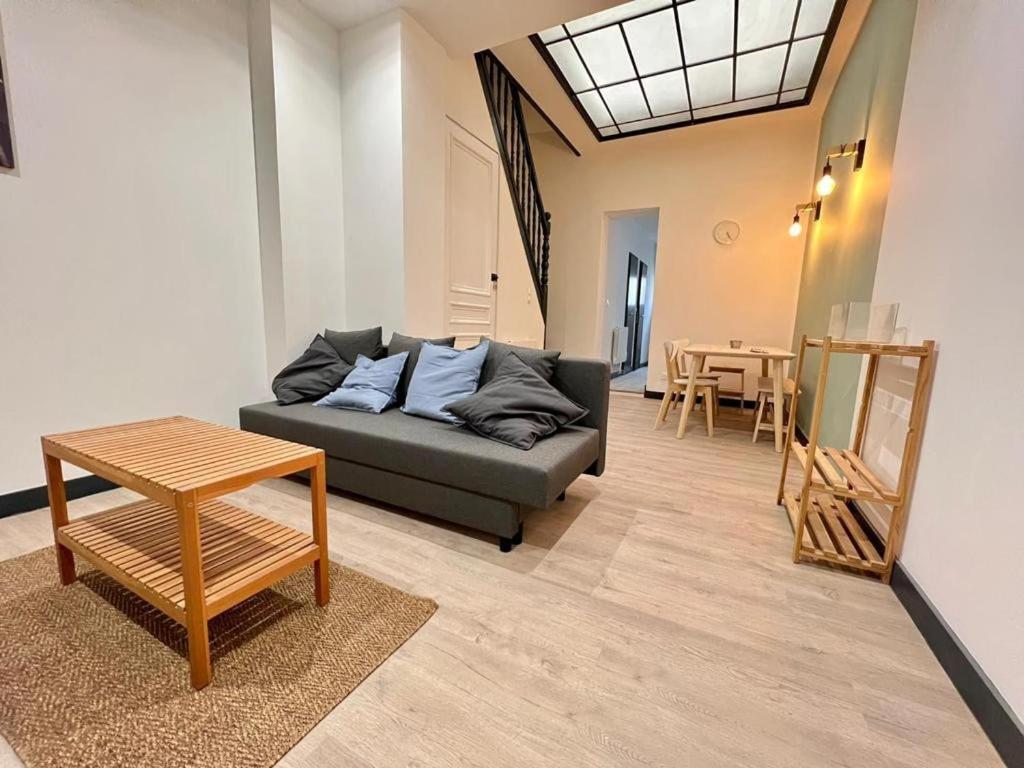 a living room with a couch and a table at Maison Lilloise 6 people heart of Roubaix in Roubaix