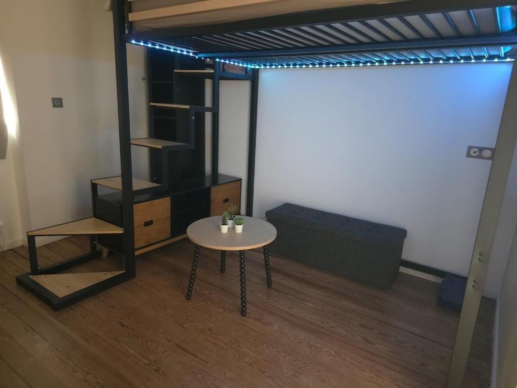 - un salon avec une table, un canapé et un lit dans l'établissement Beau studio proche gare à Dijon, à Dijon