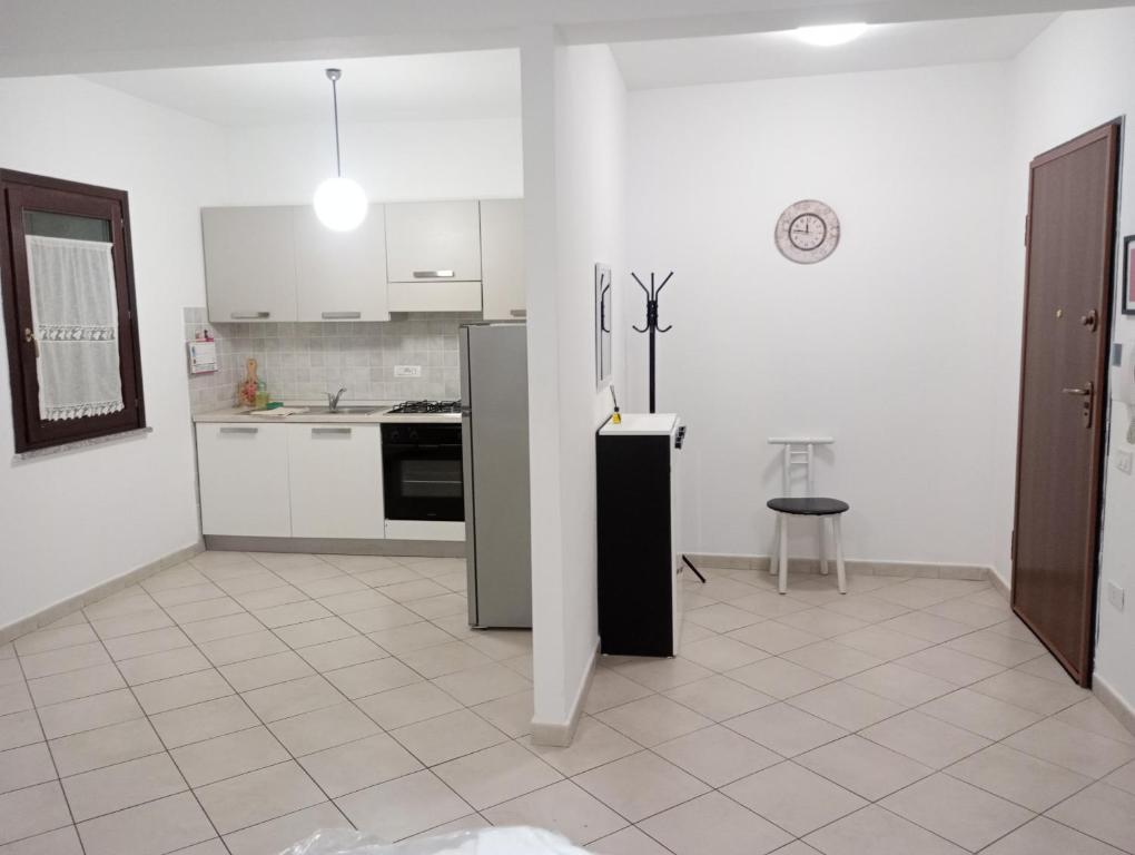 a kitchen with a refrigerator and a tile floor at La Casa di Rossella nel cuore della città , Downtown spacious apartment in Olbia