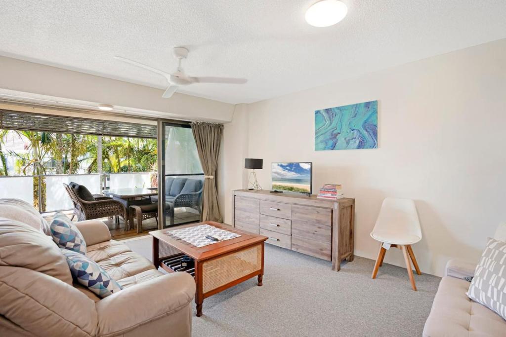 a living room with a couch and a table at Noosasoon - Central Family Friendly Holiday Apt with Pool in Noosa Heads