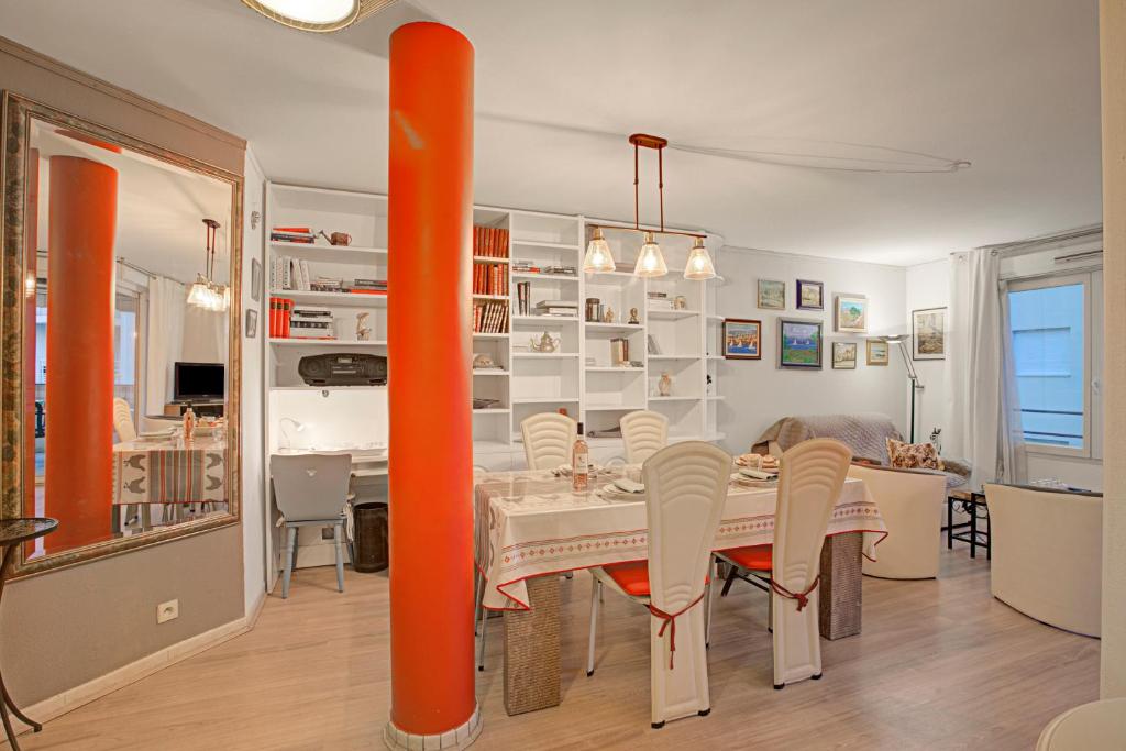 une salle à manger avec une perche orange et une table dans l'établissement Le Playa - 50m from the beach - Happy Rentals, à Fréjus