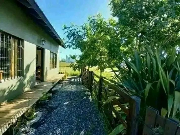 a house with a fence next to a yard at Casa de campo y mar in Camet Norte
