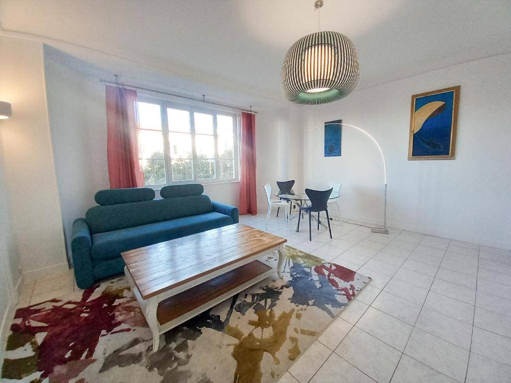 un salon avec un canapé bleu et une table dans l'établissement Palais Alexandre, à Cannes