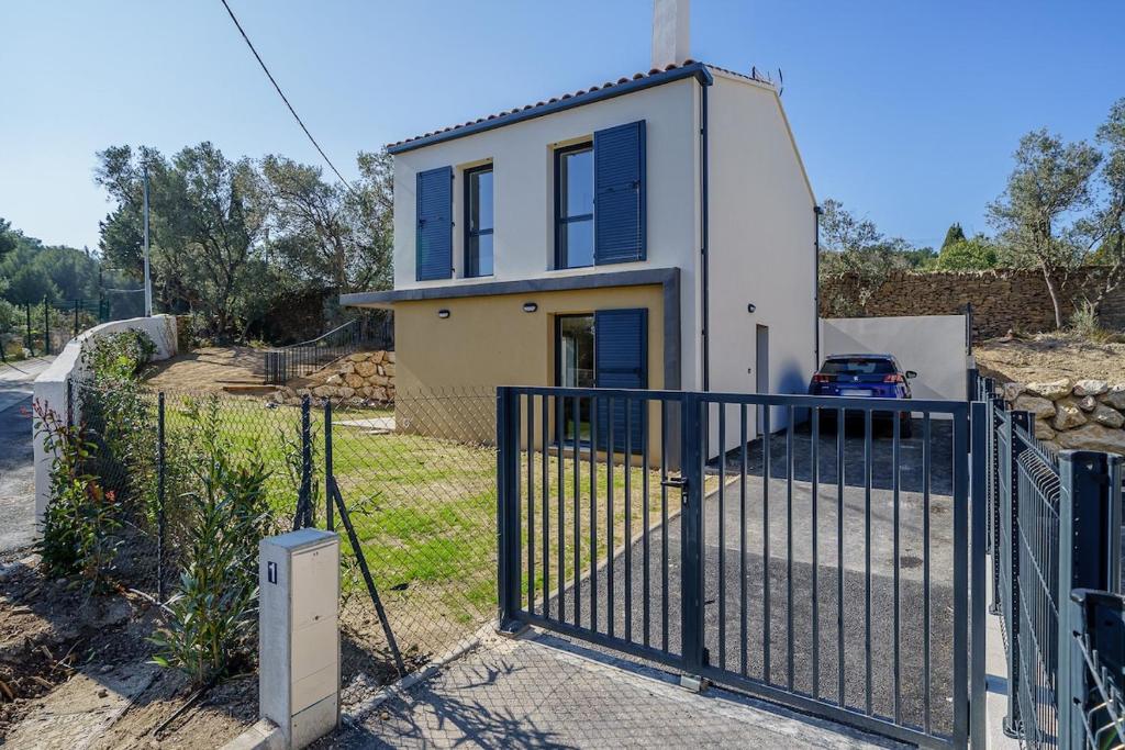 una casa con una puerta y una valla en Villa Escale Marine, Vue Mer, 3 chambres - 2 lits double et 2 lits simples, en La Ciotat