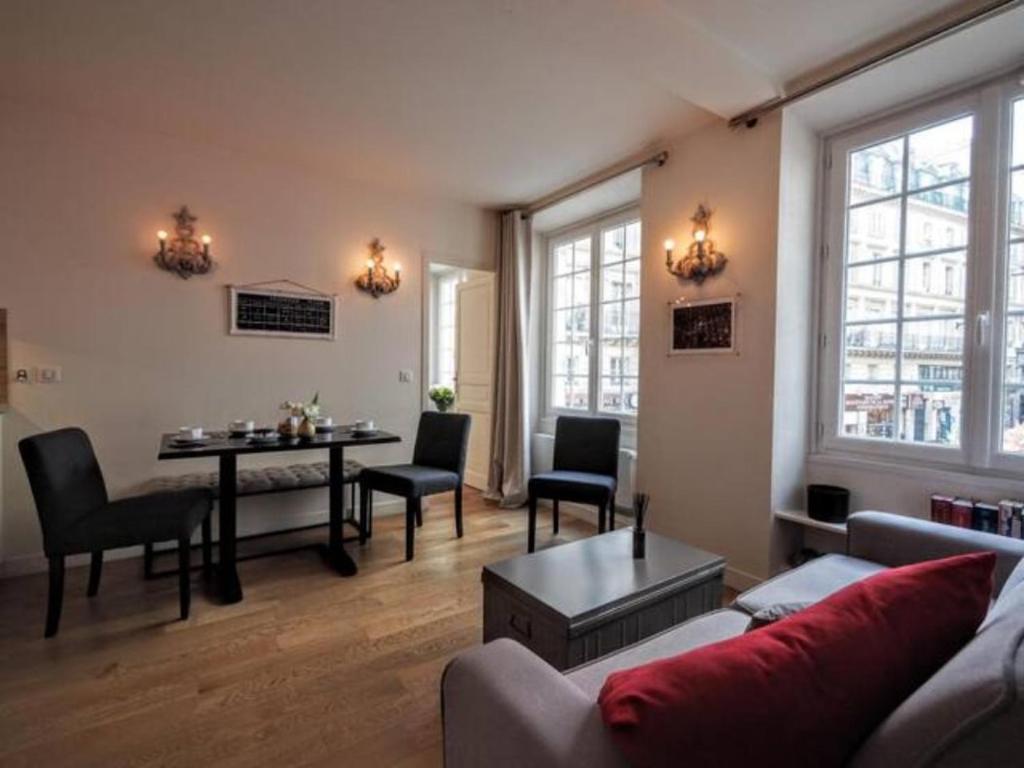 un salon avec un canapé et une table dans l'établissement Paris Louvre Bourse city center, à Paris