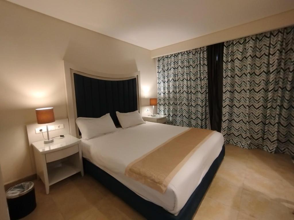 a hotel room with a large bed and a window at Beau Site Belle Vue Hotel in Marsa Matruh