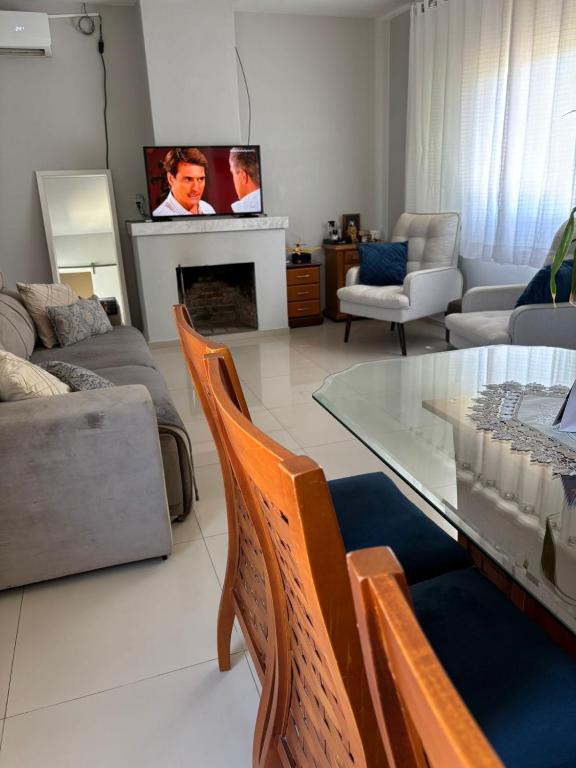 Una sala de estar con una mesa de cristal y sillas. en Casa Familiar, en São Gabriel