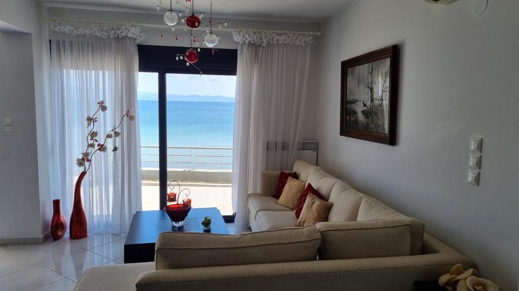 a living room with a couch and a view of the ocean at Coastal maisonette in Nea Potidaea