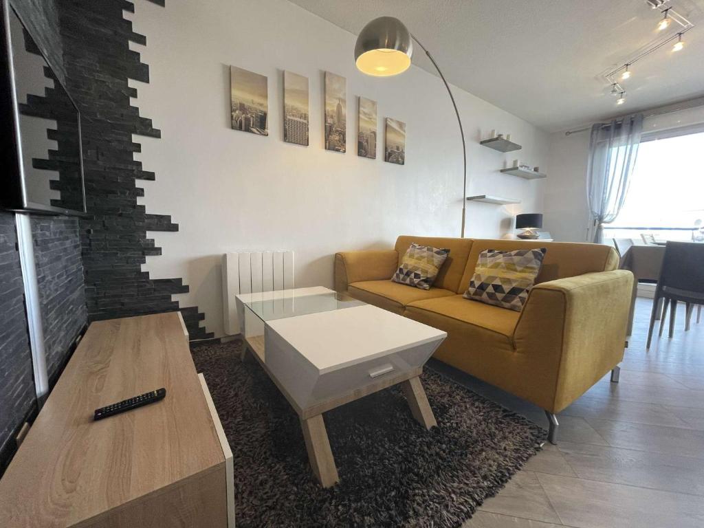 un salon avec un canapé et une table basse dans l'établissement Appartement- 3 pièces AYTRE - LR590-023, à Aytré