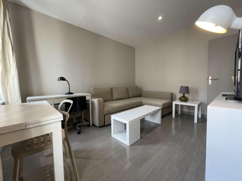 un salon avec un canapé et une table dans l'établissement Appartement T2 à La Rochelle - LR180-004, à La Rochelle