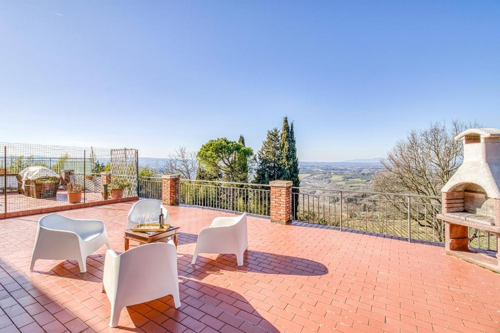 un patio con sillas blancas y chimenea en Homes Boccaccio Beautiful Terrace - Happy Rentals, en Montespertoli