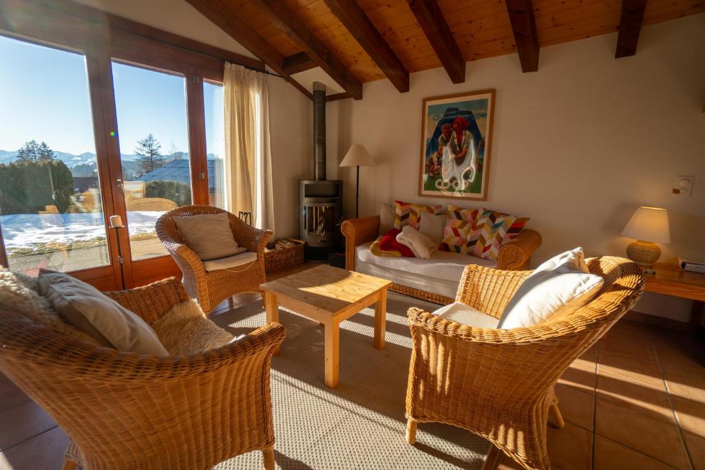 a living room with chairs and a couch and a table at Akwaaba in Gryon