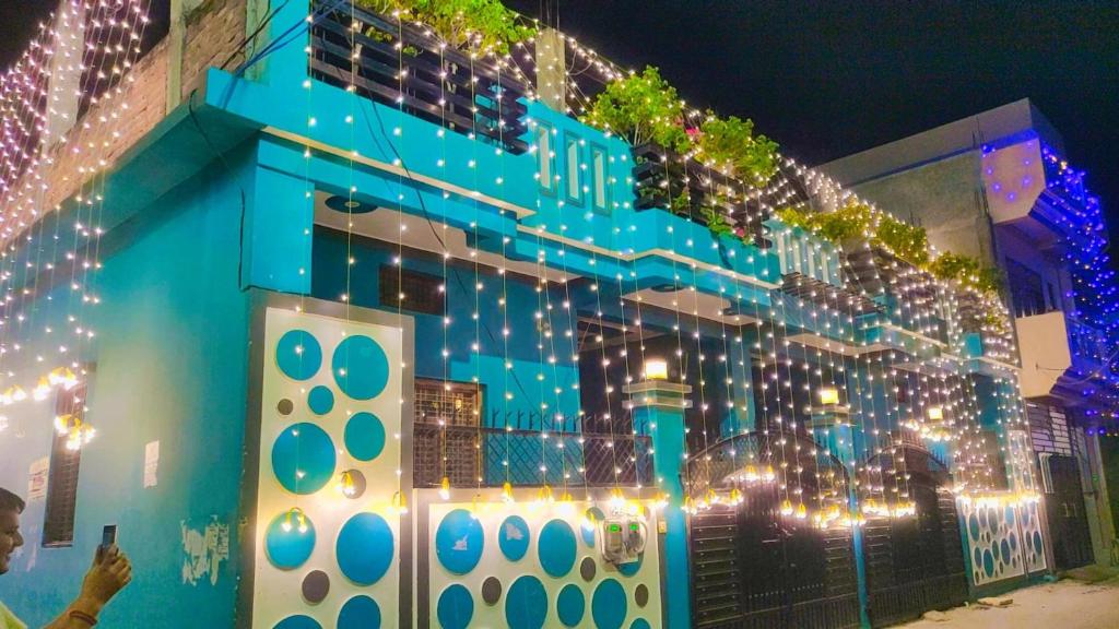 a man taking a picture of a building with christmas lights at Shobha casa in Prayagraj