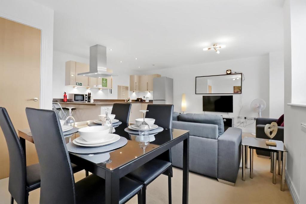 a dining room and living room with a table and chairs at Portfolio Apartments - Stevenage Town Centre in Stevenage