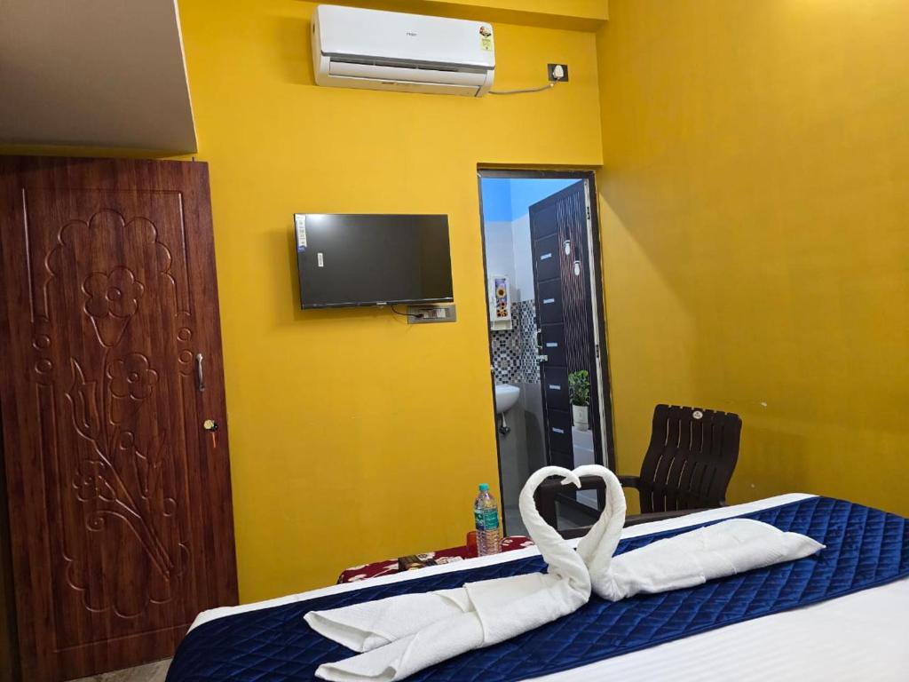 ein Hotelzimmer mit einem Bett mit einem herzförmigen Handtuch in der Unterkunft Tranquil Heaven in Puducherry