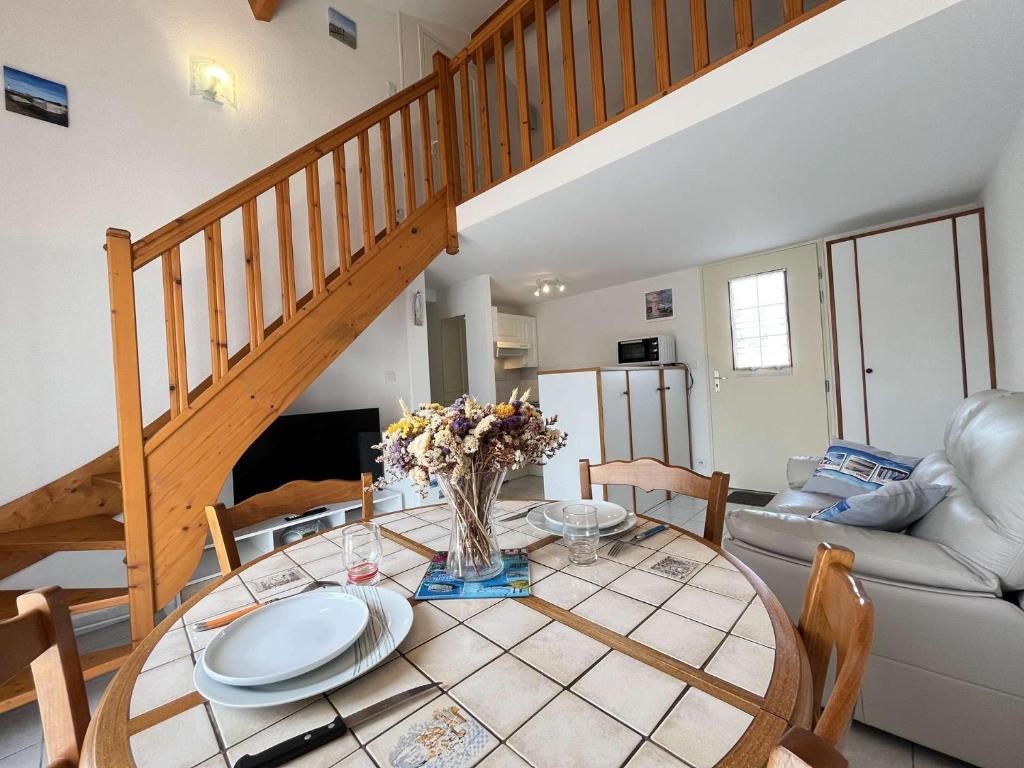 une salle à manger avec une table et un escalier dans l'établissement Maison 3 pièces mezzanine CHATELAILLON PLAGE - CL080-046, à Châtelaillon-Plage