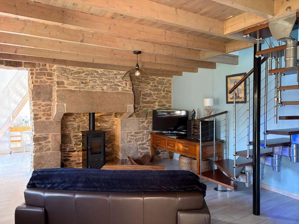 - un salon avec un canapé et une cheminée en pierre dans l'établissement Charmante maison bretonne avec jardin clos, parking, WiFi, à 900m de la plage - Trégastel - FR-1-542-35, à Trégastel
