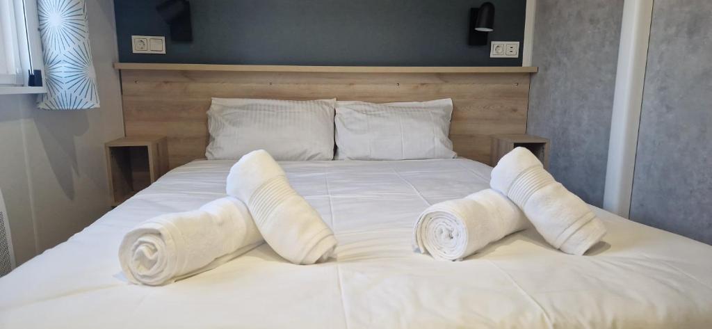 - un lit blanc avec 4 oreillers dans l'établissement Evasion au bord de l'océan, à Capbreton