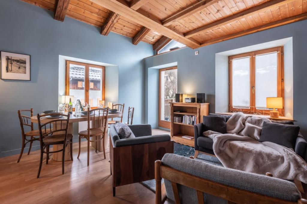 - un salon avec des murs bleus, une table et des chaises dans l'établissement Duplex T3 with terrace in Chamonix, à Chamonix-Mont-Blanc