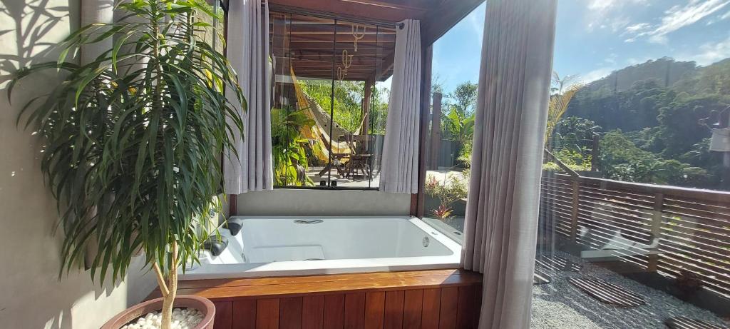 a bath tub sitting on a balcony with a window at Casa da Bella - 1,5km do centro de Lumiar in Nova Friburgo