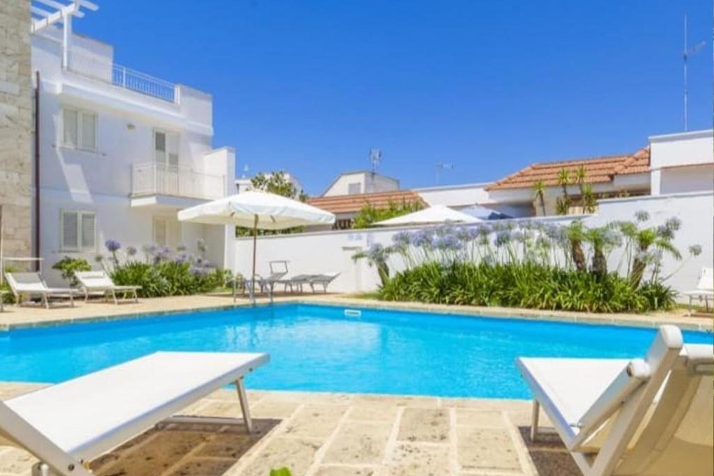 a swimming pool in front of a building at Lucrezia - Relax, Piscina, Barbeque e Wi-Fi in Nardò