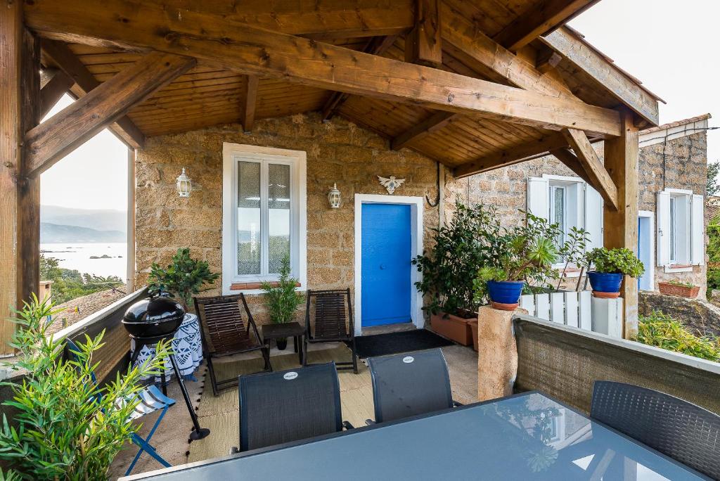 une terrasse avec une porte bleue, une table et des chaises dans l'établissement Le Mas Saint Pierre, à Pietrosella