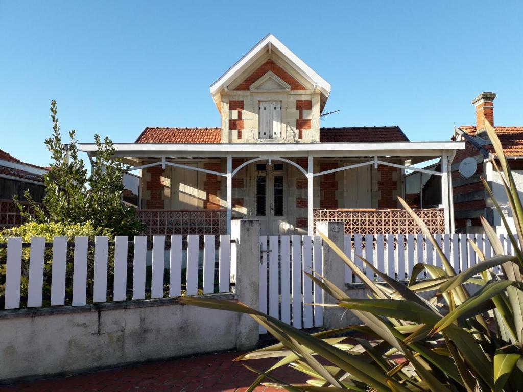 une clôture blanche devant une maison dans l'établissement villa soulacaise proche du marche, à Soulac-sur-Mer