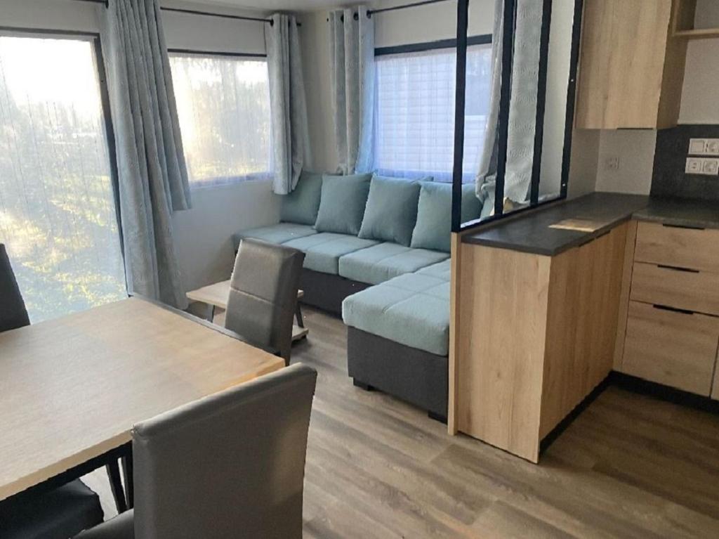 a living room with a couch and a table at MH 3CH à l'océan Landais chez Claiclé in Saint-Julien-en-Born