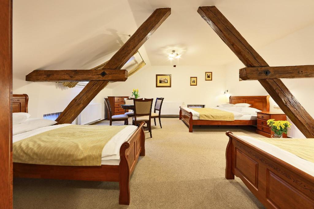 a room with two beds and a table in it at Pension Rozmarýna in Český Krumlov