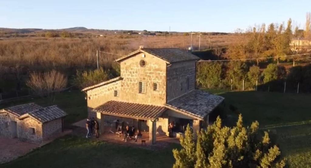 una vista aérea de un gran edificio de piedra en un campo en NoxRomana Beautiful Casale in Tuscia, en Capranica