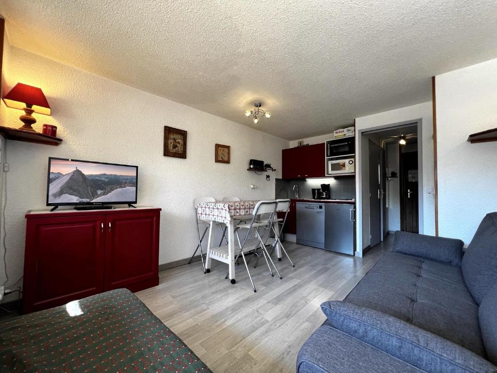 un salon avec un canapé et une cuisine dans l'établissement Alcyon A23 - Studio proche pistes, à La Clusaz