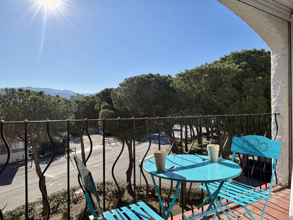 d'une table et de chaises sur un balcon avec vue sur la rue. dans l'établissement Studio cabine à 200m de la plage, loggia ensoleillée, quartier calme - 4 couchages - FR-1-225-214, à Argelès-sur-Mer