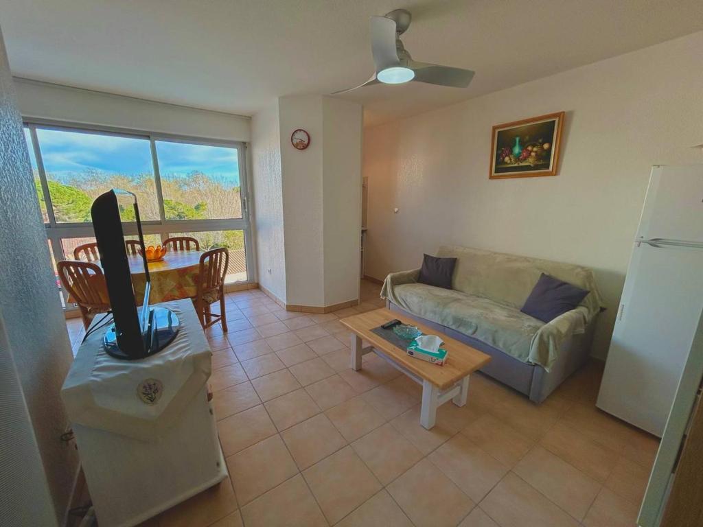 un salon avec un canapé et une table dans l'établissement Appartement T2 Lumineux avec Parking Privé et Piscine près de la Plage - FR-1-388-223, à Argelès-sur-Mer
