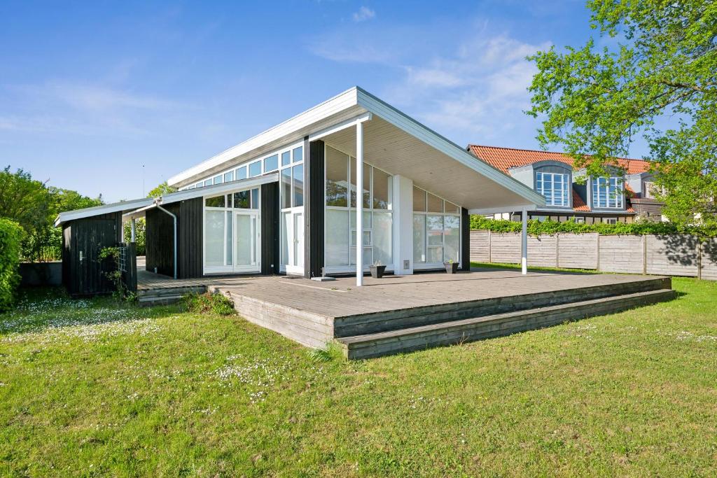 une maison avec une grande terrasse et des fenêtres en verre dans l'établissement Beautiful And Well-Designed Holiday Home With Sea View, Spacious Terraces And Spa Just 200 Metres From The Child-Friendly Femmøller Beach And Close, à Ebeltoft