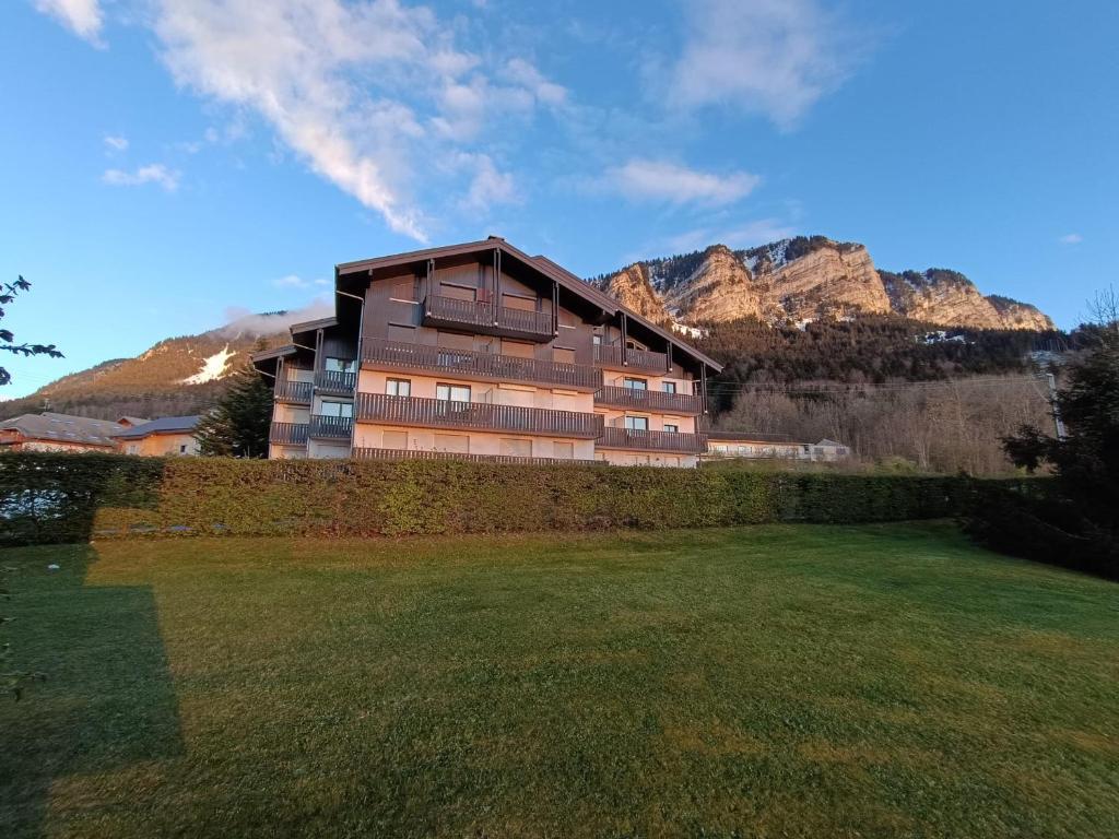 un bâtiment avec une pelouse devant lui dans l'établissement Appartement cosy proche pistes ski avec garage - FR-1-498-112, à Thollon-les-Mémises