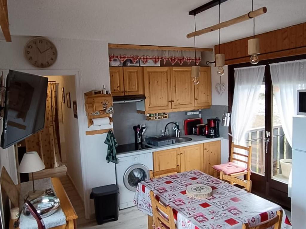 a small kitchen with a table and a sink at Appartement cosy proche pistes ski avec garage - FR-1-498-112 in Thollon