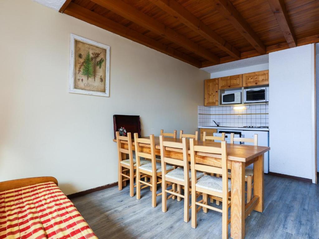 une cuisine et une salle à manger avec une table et des chaises en bois dans l'établissement Duplex cosy sous les toits, pied des pistes, animaux admis - FR-1-811-21, à Les Deux Alpes