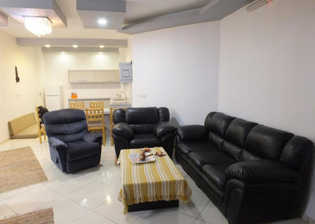 a living room with a couch and two chairs and a table at Hermon Garden Apartment in Majdal Shams